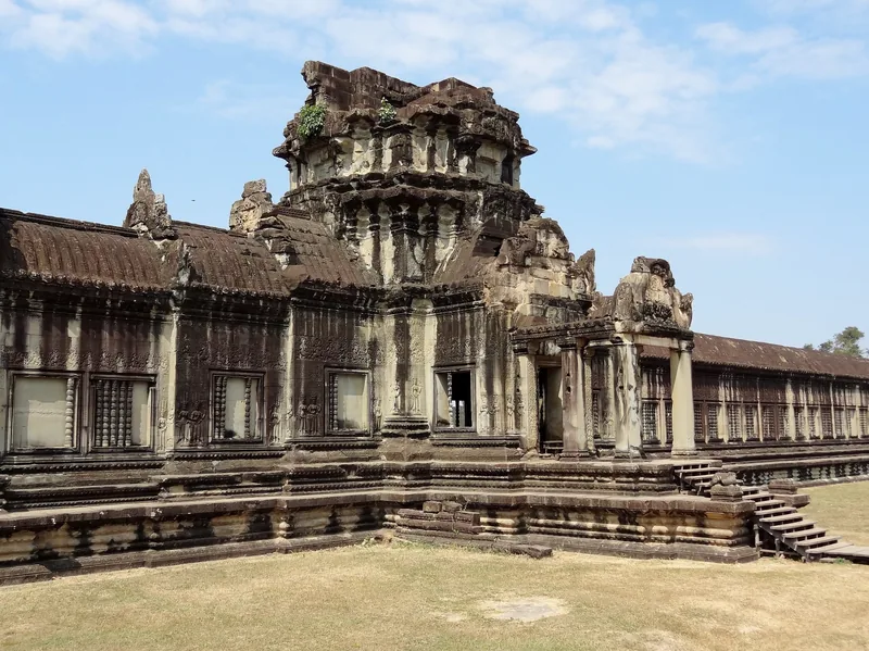 A weathered stone gopura tower rises above the long galleries of Angkor Wat in Siem Reap.