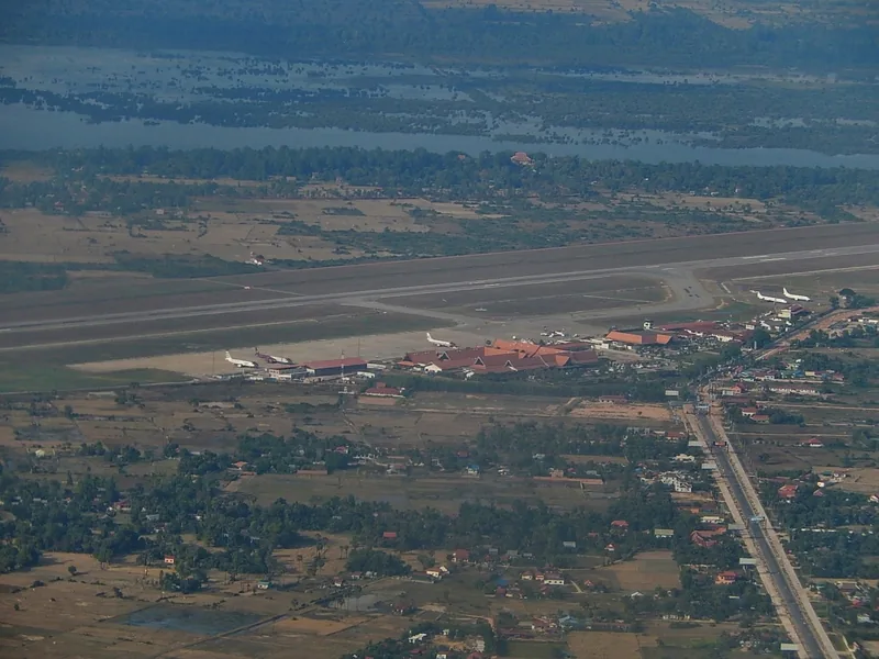 Aerial view of Siem Reap Airport runway and terminal surrounded by rice fields and villages