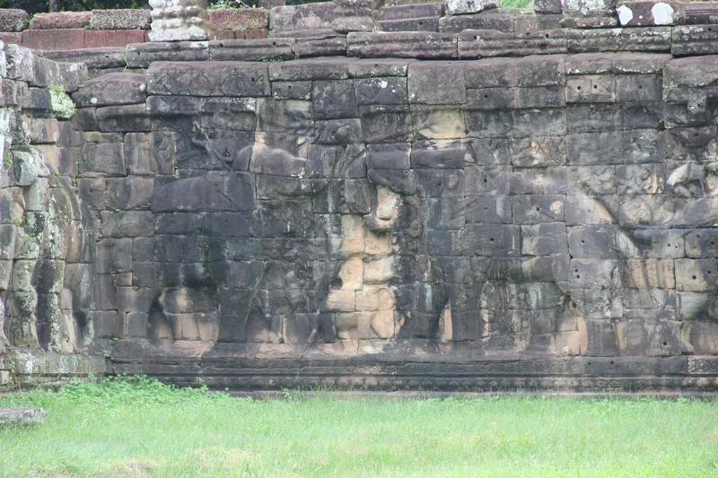 Weathered stone carvings of elephants on the ancient wall of the Terrace of the Elephants in Angkor Thom.