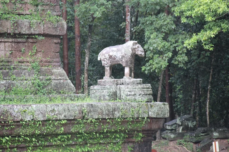 A weathered stone lion statue stands atop the ancient terrace at Phimeanakas temple in Angkor Thom, Siem Reap.