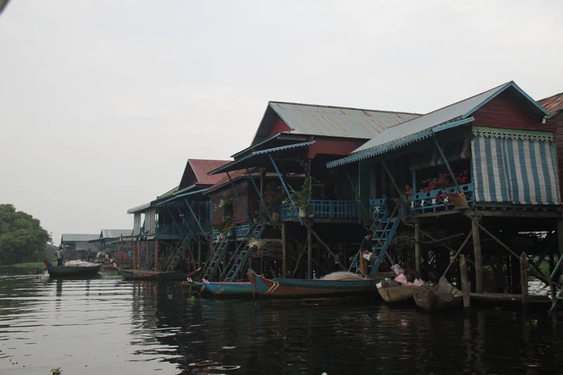 Wooden stilt houses and boats line the water at a floating village on Tonle Sap Lake near Siem Reap.