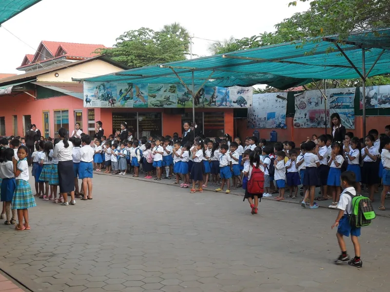 Uniformed schoolchildren line up in a courtyard outside a school building in Siem Reap.