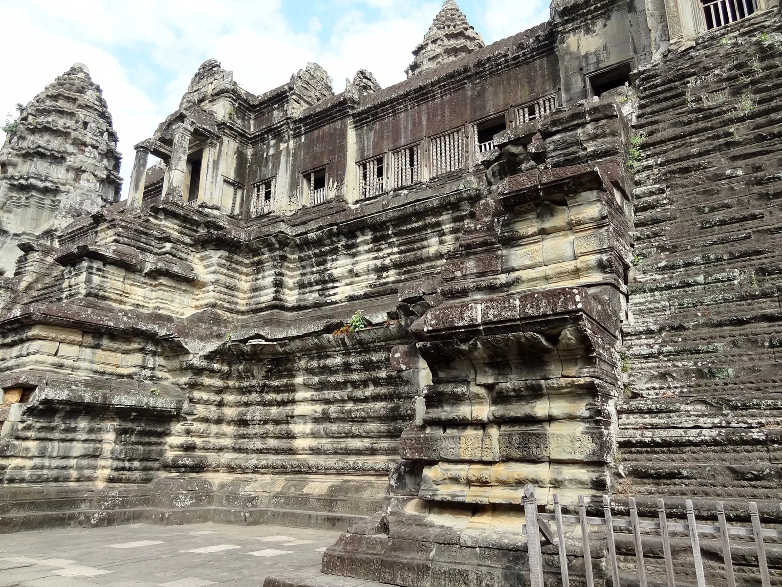Weathered sandstone towers and steep stairways rise from the ancient walls of Angkor Wat in Siem Reap.