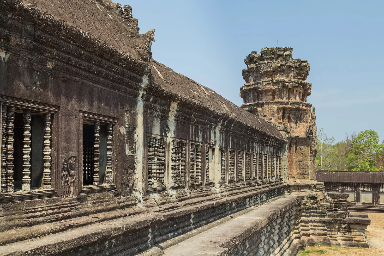 Stone corridor with carved window balusters lines the outer gallery of Angkor Wat in Siem Reap.