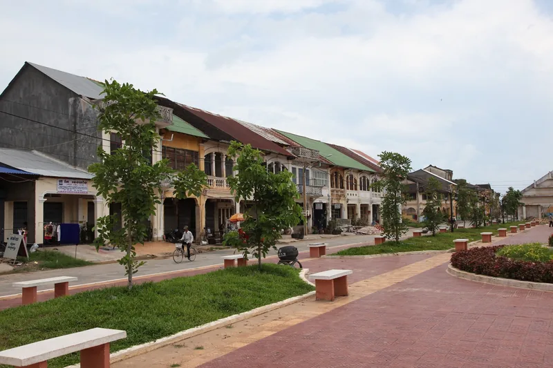 A row of colonial-era shophouses lines the riverside promenade in Kampot, Cambodia.