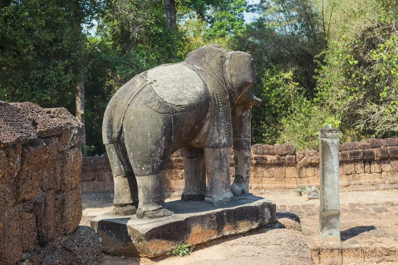 A weathered stone elephant statue stands at the corner of Pre Rup temple in Siem Reap.