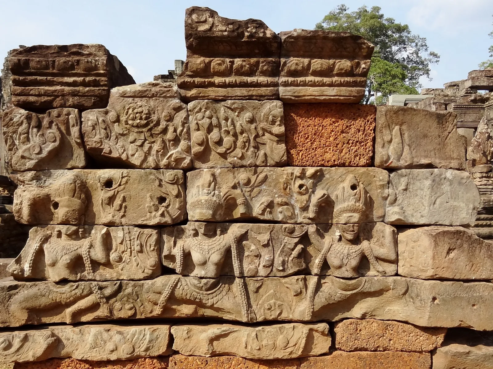 Weathered sandstone carvings of apsara figures on an ancient temple wall at Angkor Thom's Bayon in Siem Reap