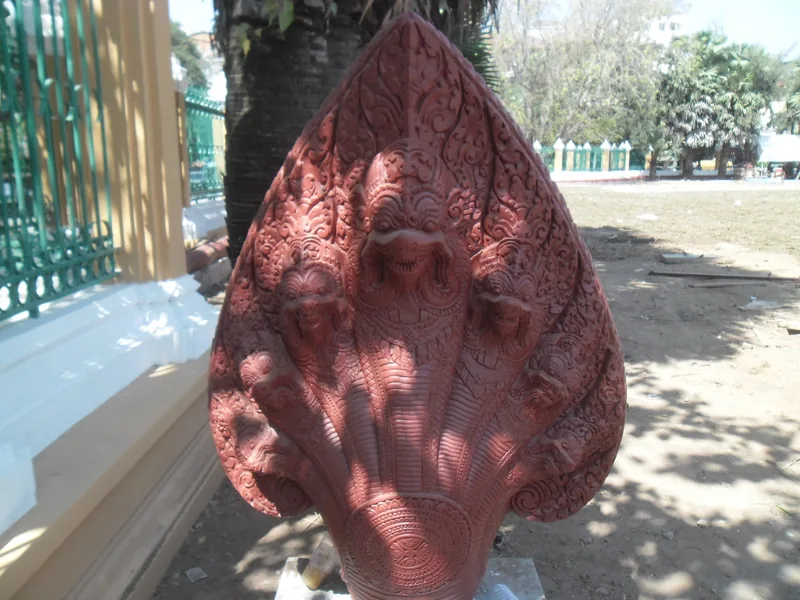 A carved multi-headed naga sculpture stands in a courtyard in Phnom Penh, Cambodia.