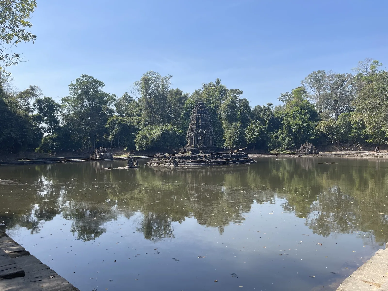 A small stone shrine sits on an island surrounded by a calm pool at Neak Poan temple near Siem Reap. A small stone shrine sits on an island surrounded by a calm pool at Neak Poan temple near Siem Reap.