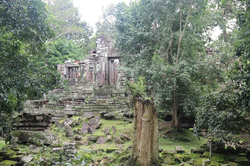 Moss-covered stone ruins of Preah Pithu temple sit surrounded by dense jungle near Angkor Thom.