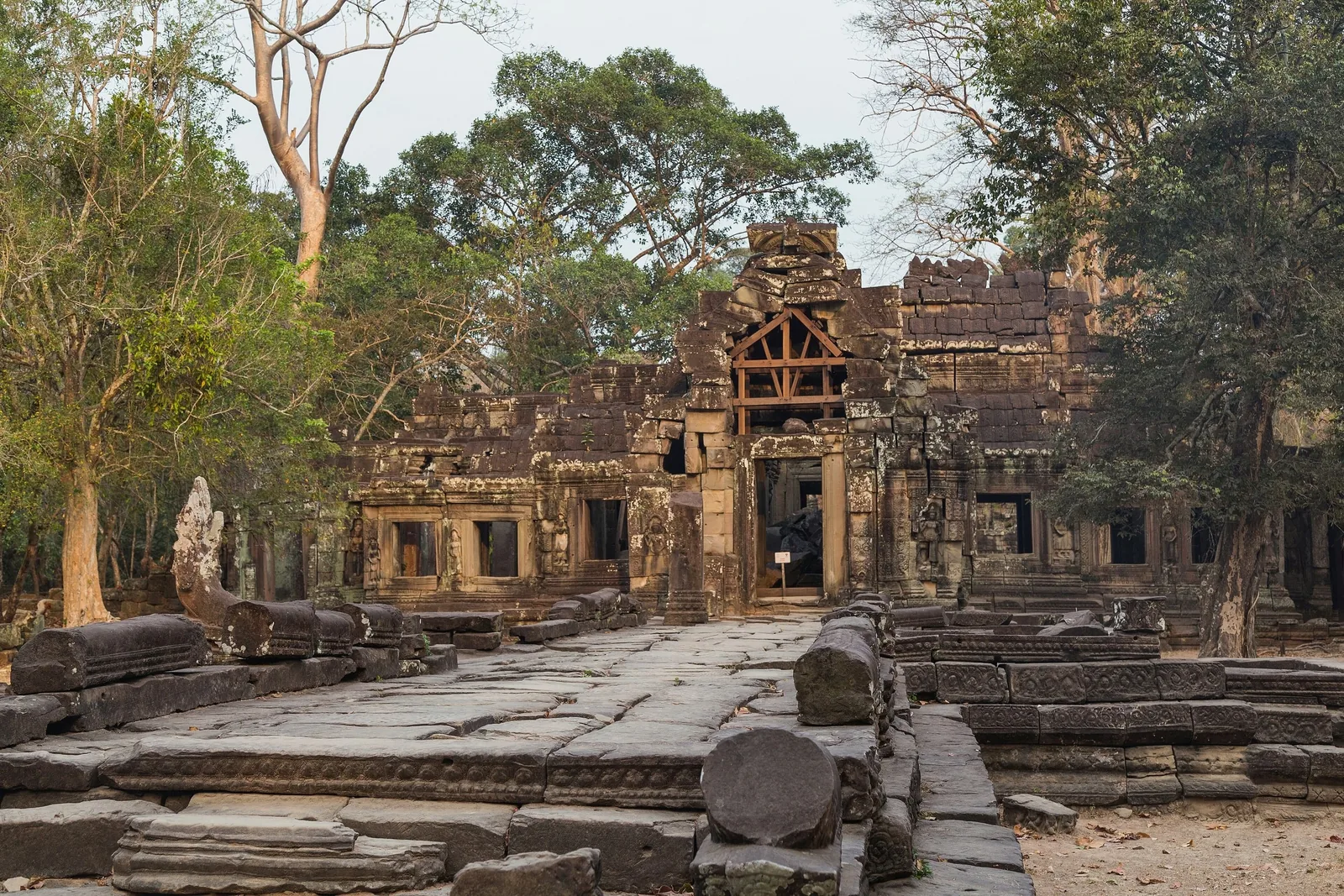 Ancient stone ruins of Banteay Kdei temple stand amid trees in Siem Reap, Cambodia.